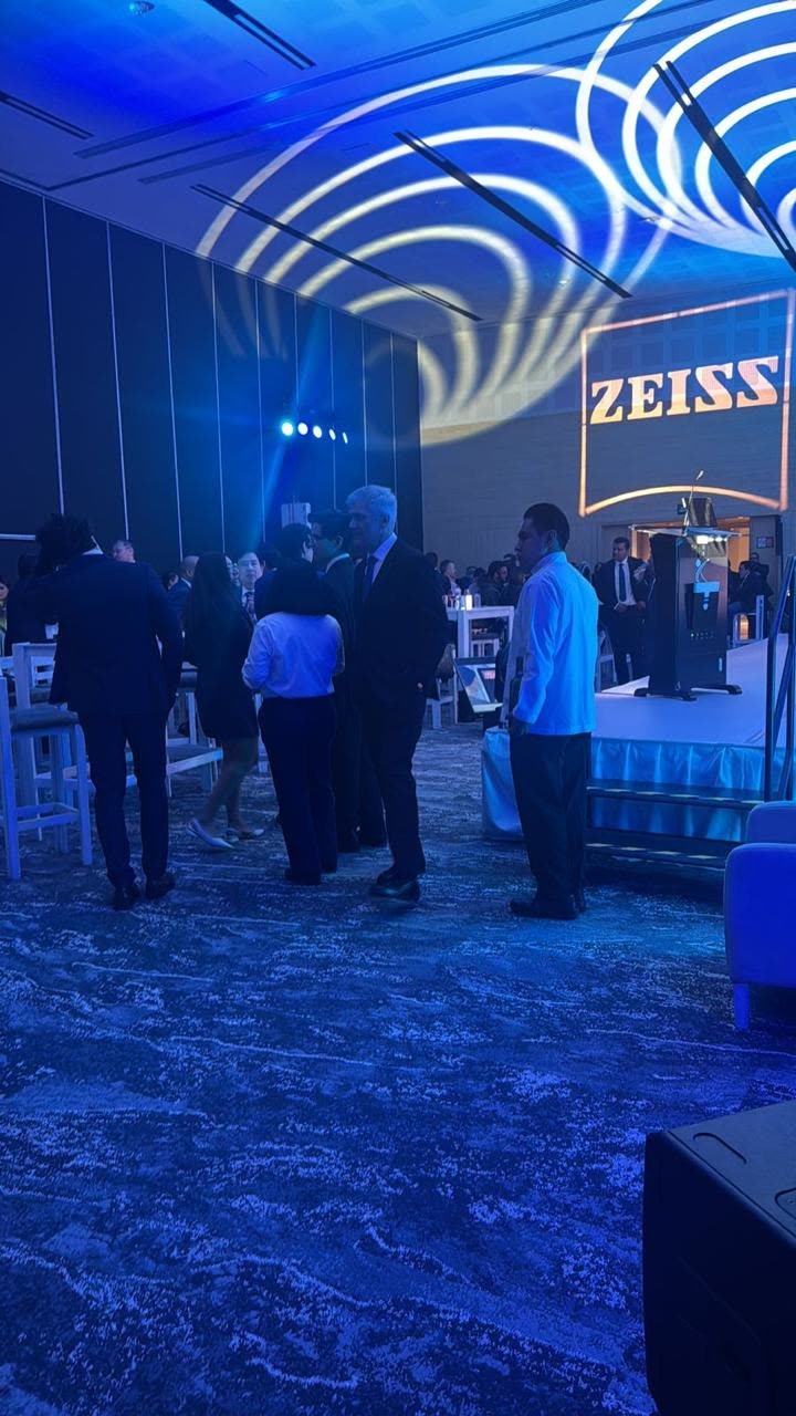 Invitados en coctel de networking con iluminación azul y gobos