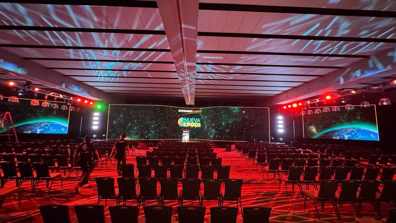 Convención corporativa con pantallas LED de gran formato y escenario iluminado