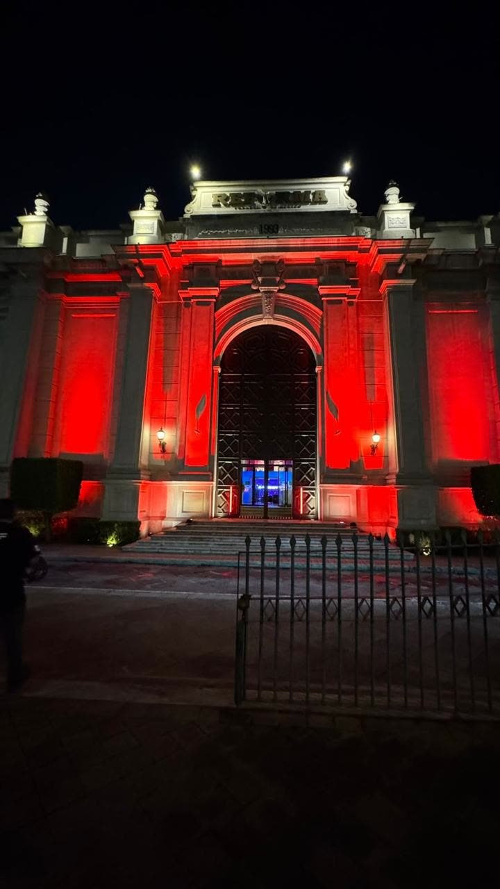Fachada de recinto histórico con iluminación arquitectónica roja producida por Profesionales en Eventos ELT